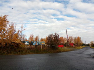 picture of real estate commercial land on olive road in Anchorage Alaska. Corner picture with blue equipment in background.